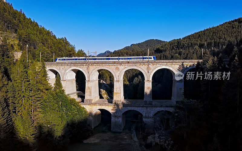 旅客列车乘坐在著名的Kalte Rinne高架桥上历史悠久的塞默林铁路(塞默林铁路)，下奥地利。